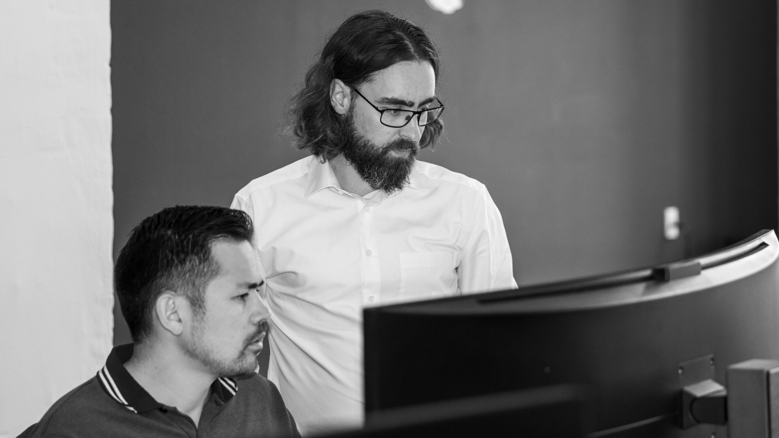 two people looking at a big pc screen