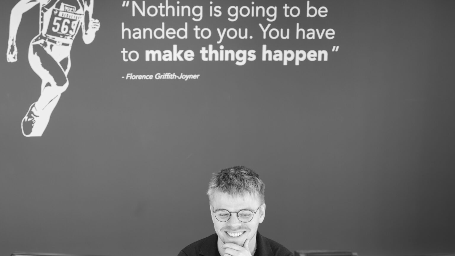 man smiling, while sitting in an office